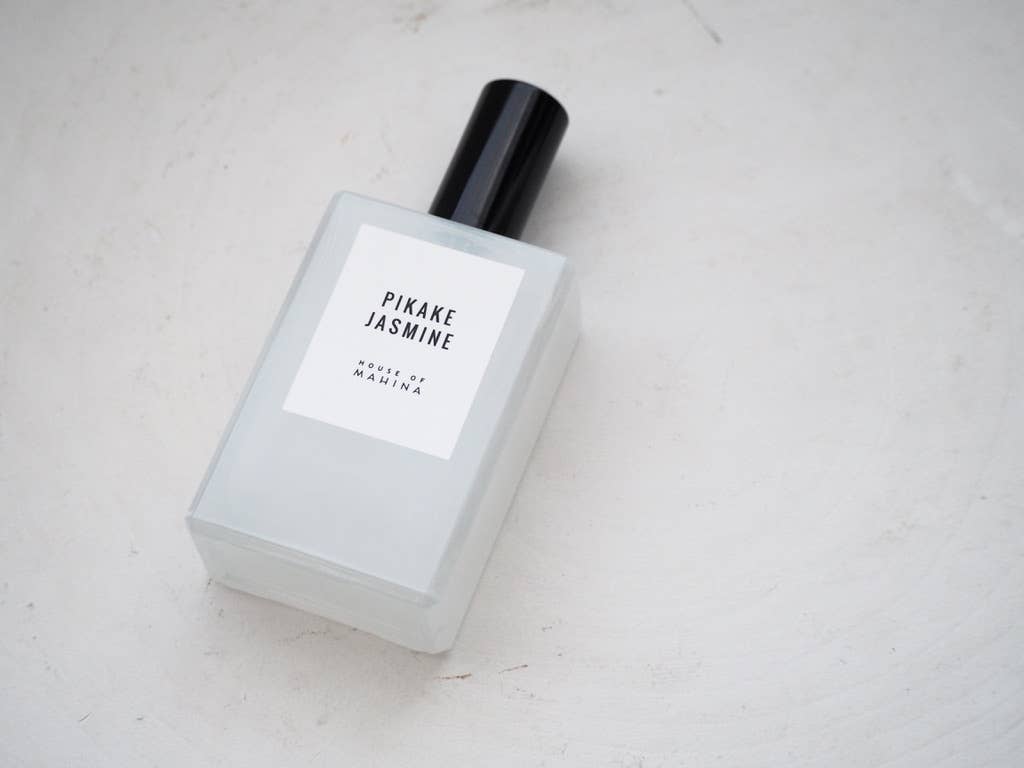 Pikake Jasmine mist bottle lying on its side on a white textured surface