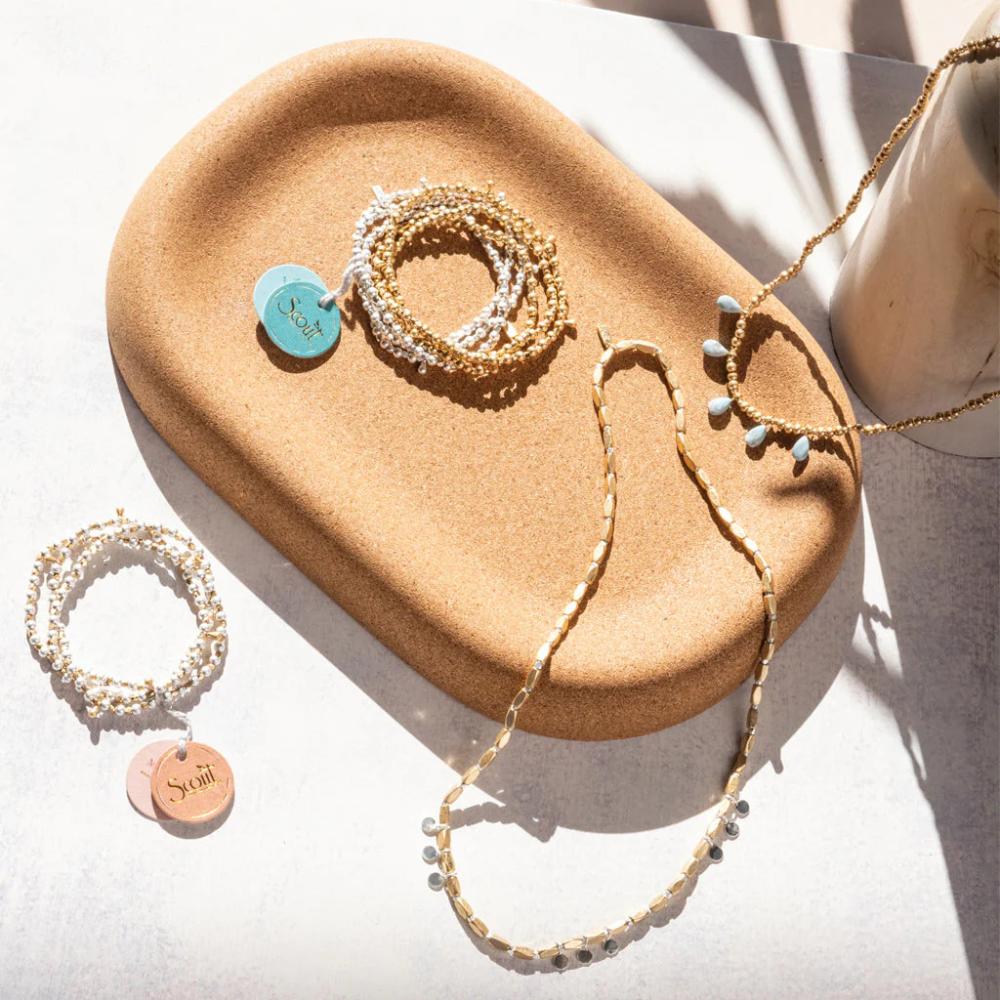 Scout Gold and Rose Quartz Timeless Wrap lifestyle shot on tabletop styling