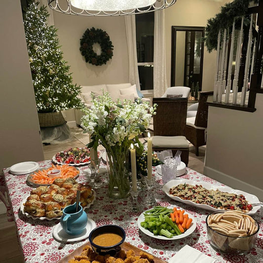 Holiday table set for Christmas dinner party inside of a festive home
