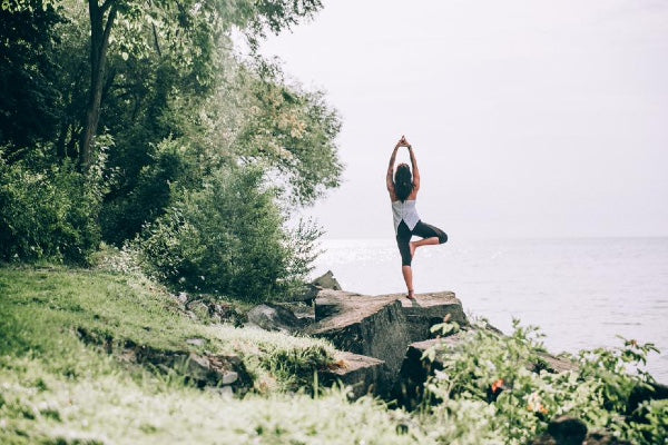 Woman doing yoga tree pose out in nature