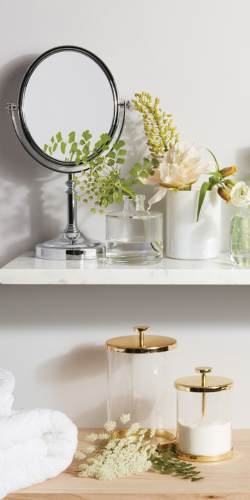 White bathroom decorated with candles, succulents, white cotton towels and polished stones