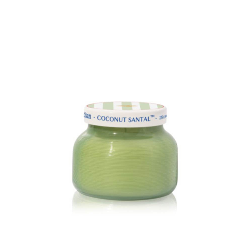 A small round jar of Coconut Santal body butter in a light green shade, featuring a white lid with blue text and a green-and-white checkered pattern, set against a plain white background.