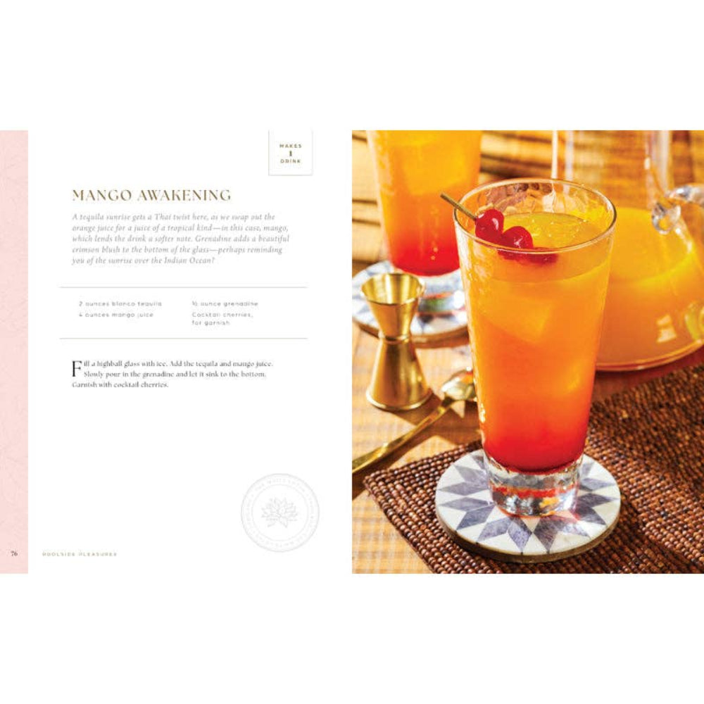 Mango cocktail in a glass with a red cherry on a coaster, surrounded by bar tools on a wooden surface.