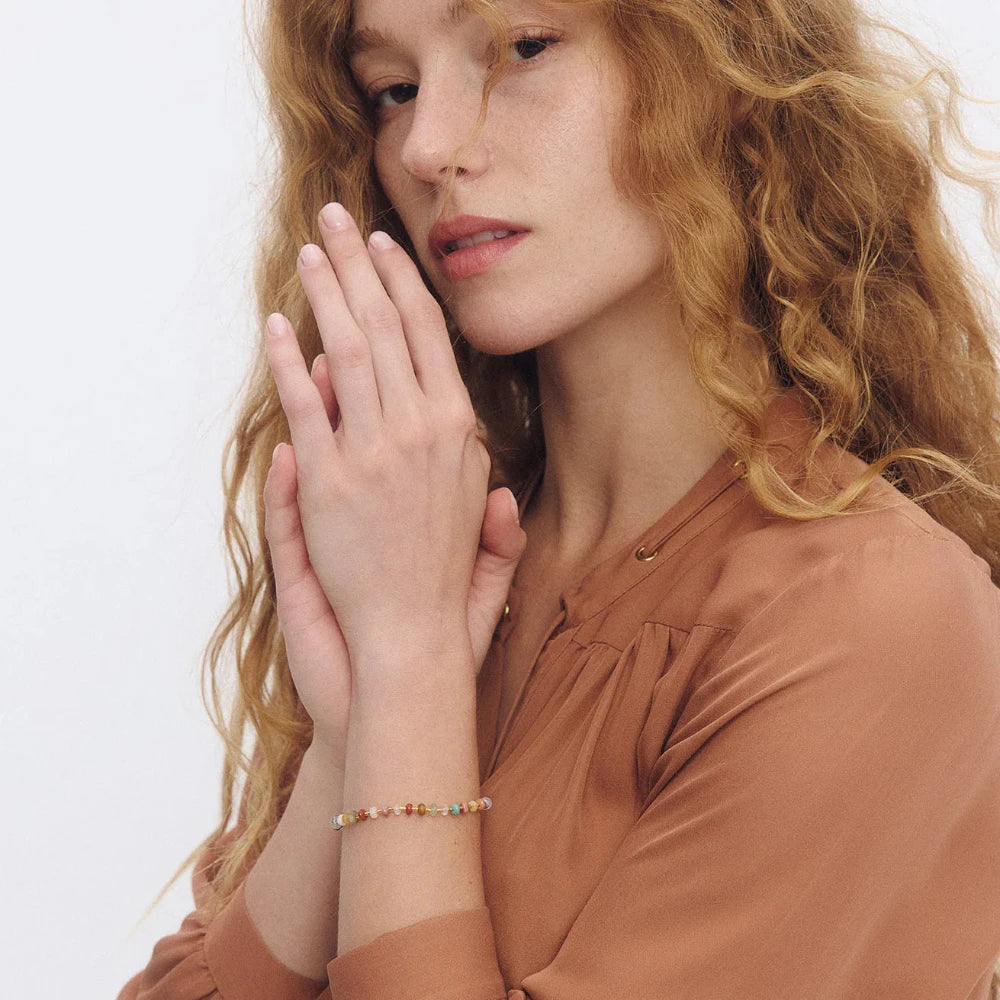 Woman wearing a bracelet with a neutral background