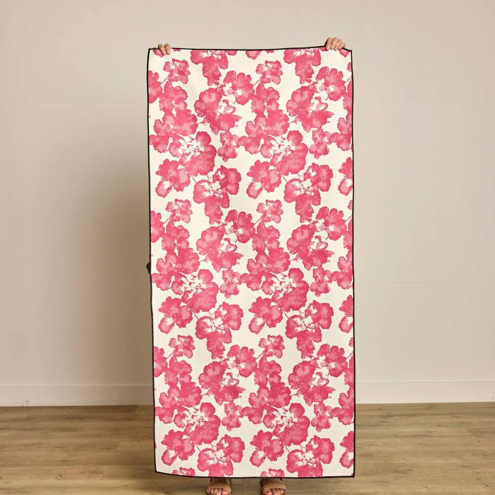 Floral patterned Fleures Tropicales Beach towel being held by a person background