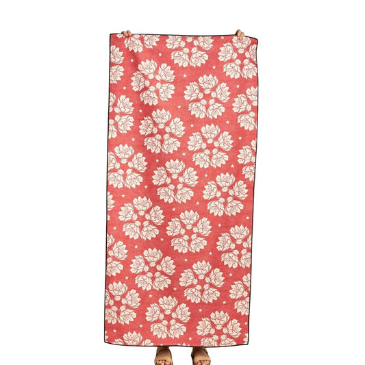 Floral patterned towel on a wooden floor with a plain wall background