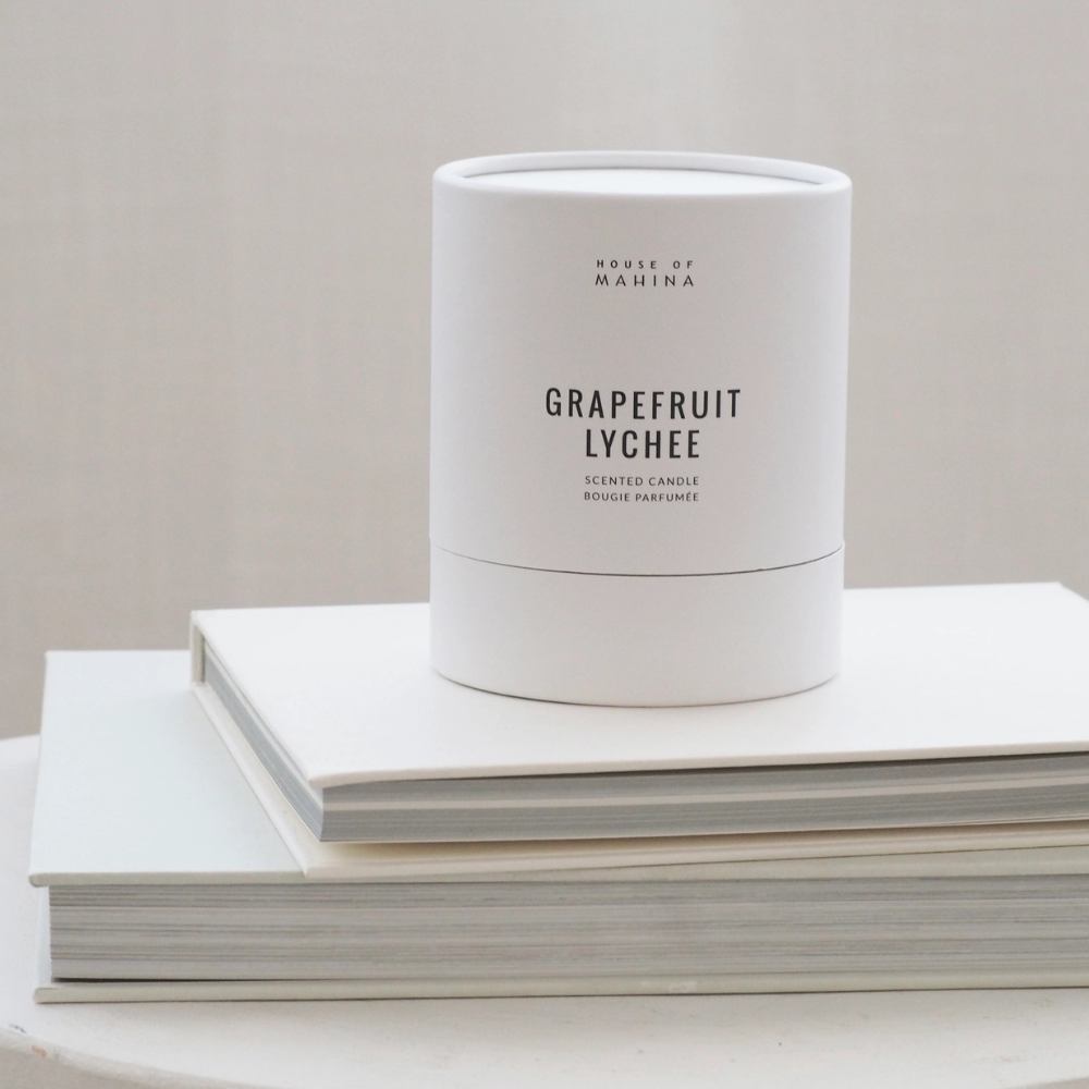 Grapefruit lychee candle box on stack of books  
