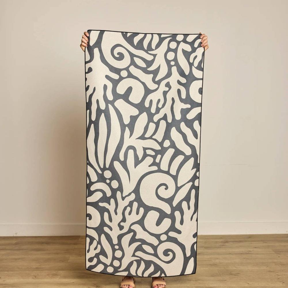 Person holding the Inkwell Reef Beach Towel made by Geometry