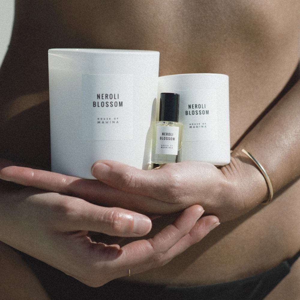 Woman holding Neroli Blossom large and small candles and Neroli Blossom perfume