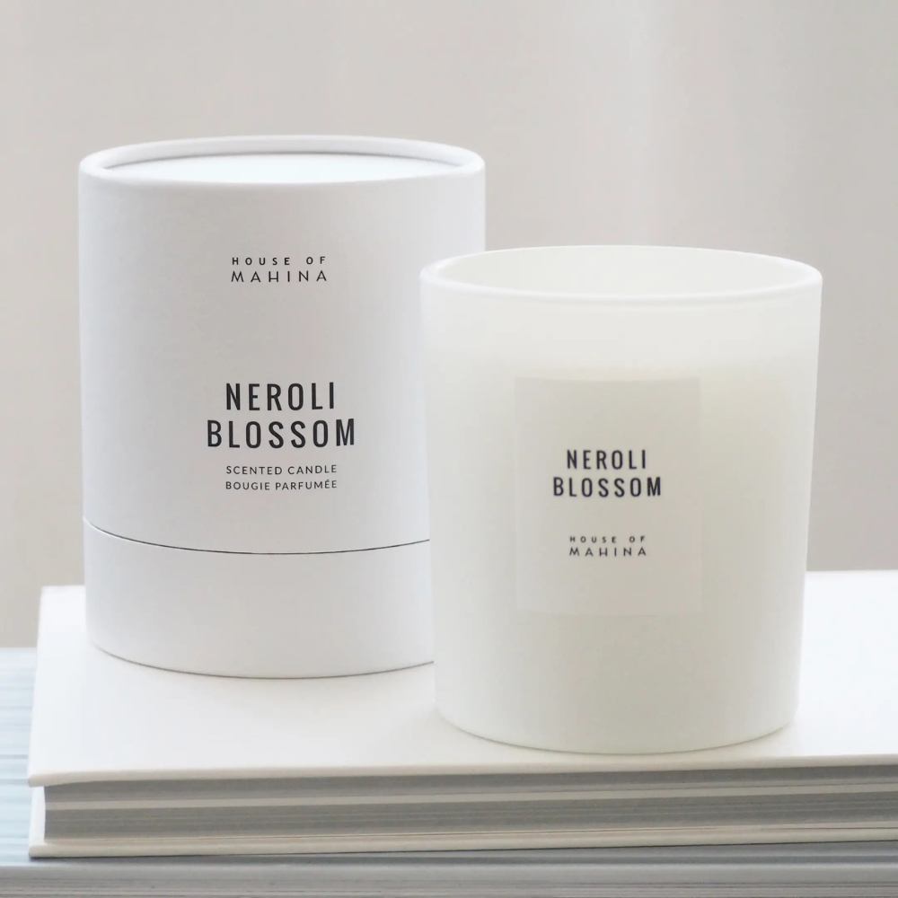 Neroli Blossom candle and round candle box on stack of white books