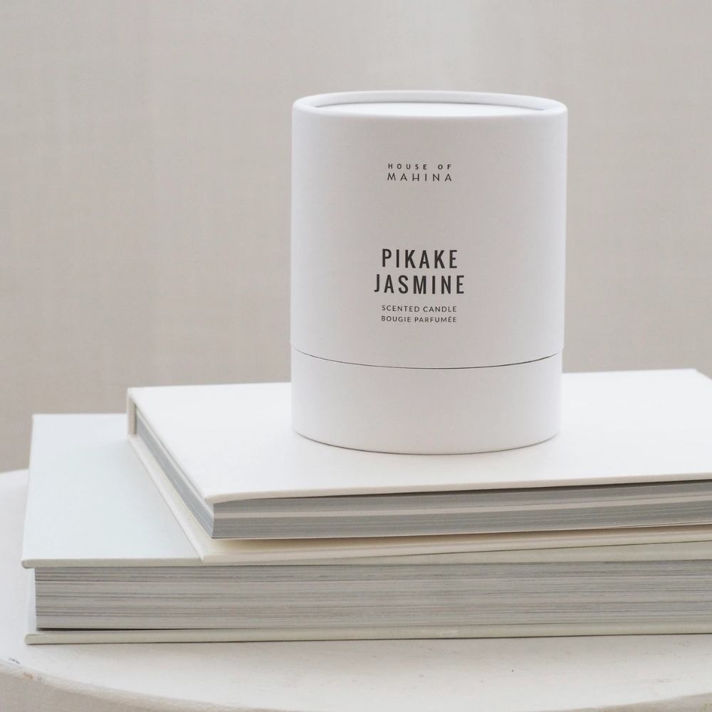 Pikake Jasmine round candle boxon stack of white books