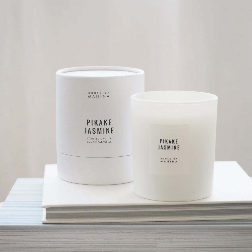 Pikake Jasmine candle and round box on stack of white books