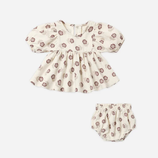 A baby girl's two-piece outfit set featuring a short-sleeve puff-sleeve top and matching bloomers, both in a cream-colored cotton fabric with a rust floral pattern, shown on a plain light background.