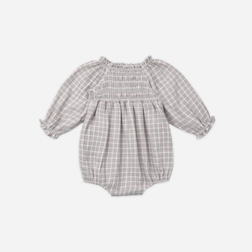 A baby girl's long-sleeve bubble romper in a light blue and white gingham plaid pattern, featuring a smocked bodice and ruffled sleeves, shown against a plain light gray background.