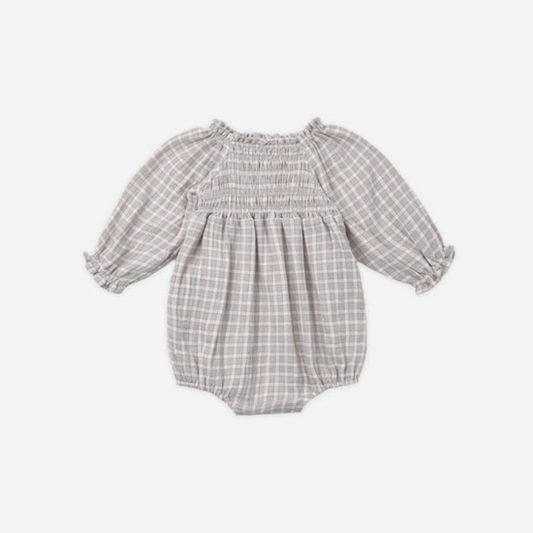 A baby girl's long-sleeve bubble romper in a light blue and white gingham plaid pattern, featuring a smocked bodice and ruffled sleeves, shown against a plain light gray background.