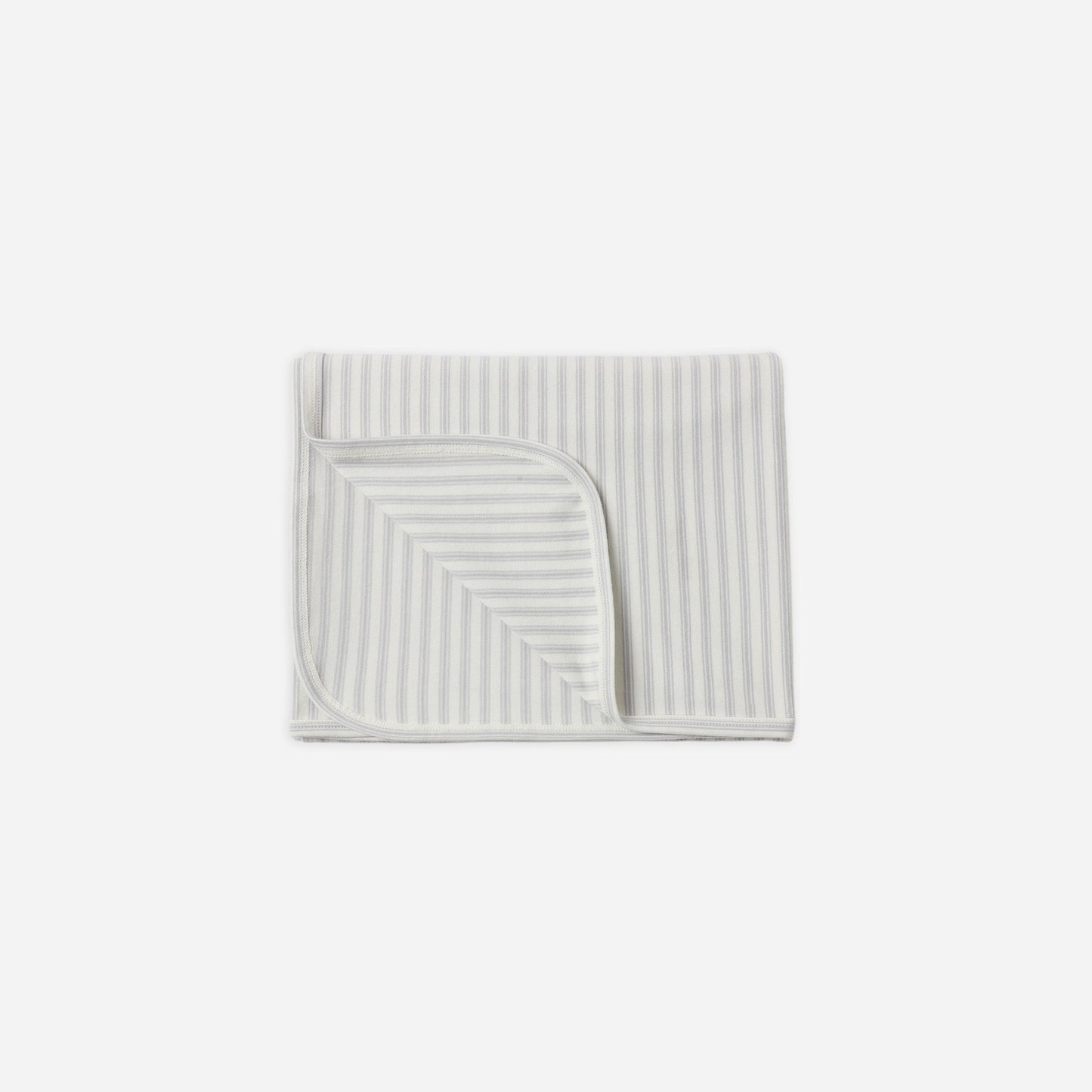 A folded baby blanket with thin vertical stripes in light blue and white, featuring a triangular patch of solid white fabric on one corner, shown on a plain light gray background.