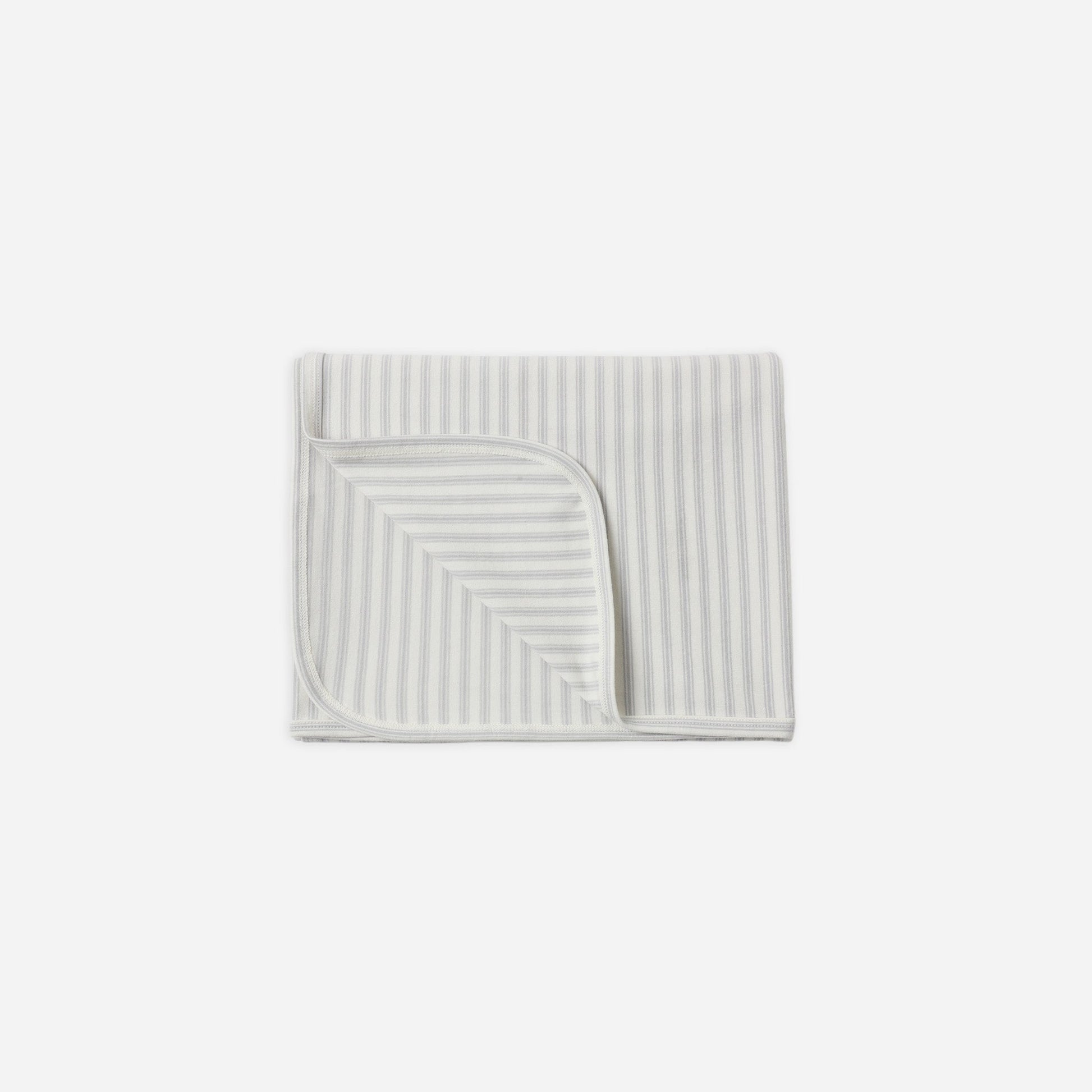 A folded baby blanket with thin vertical stripes in light blue and white, featuring a triangular patch of solid white fabric on one corner, shown on a plain light gray background.