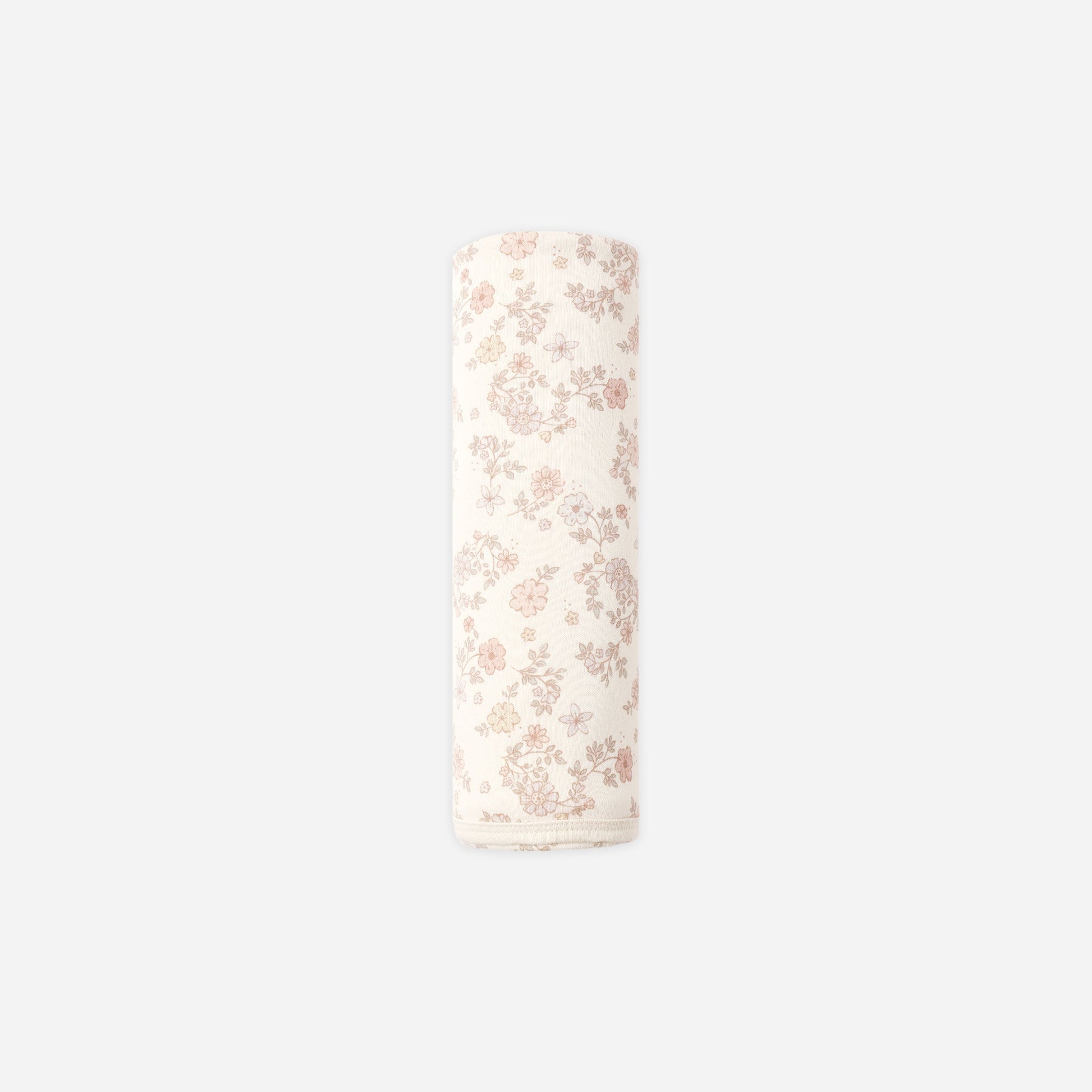 A rolled-up cream-colored fabric item, likely a muslin cloth or baby blanket, featuring a delicate pink floral pattern, shown against a solid light gray background.
