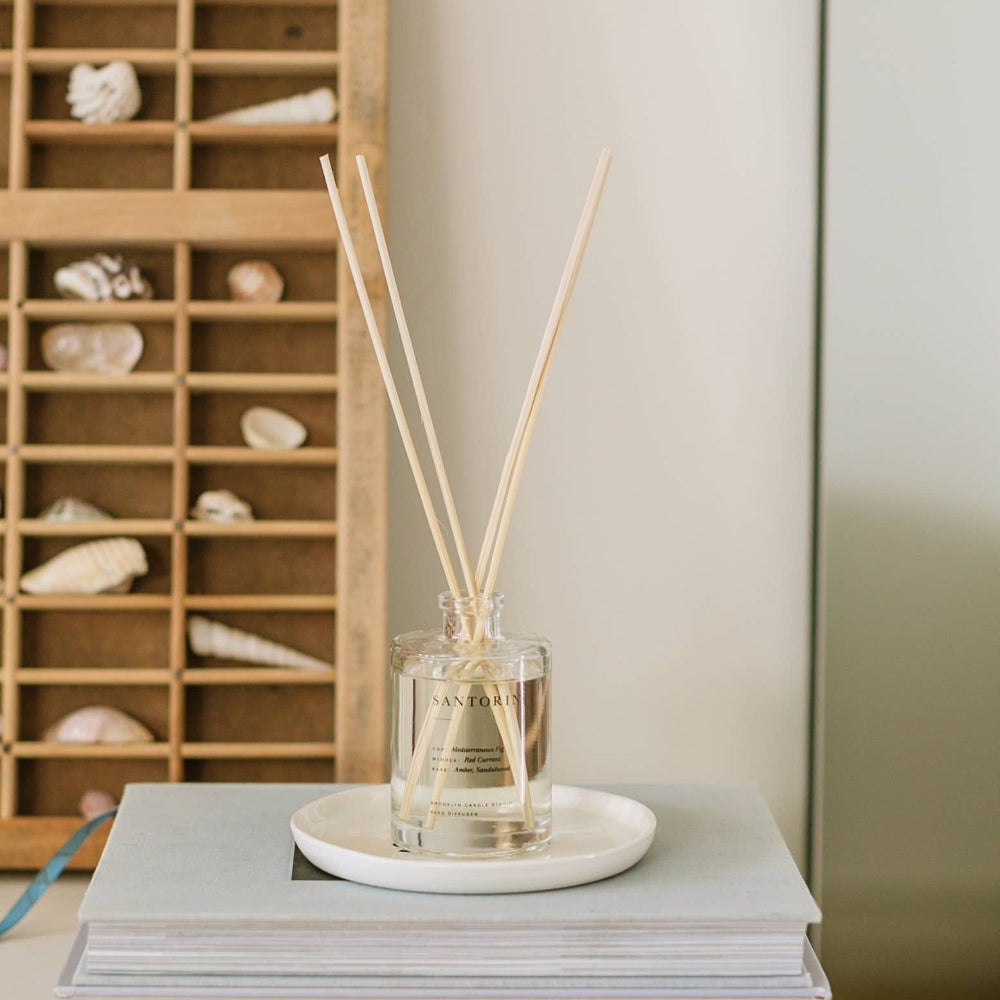 Santorini reed diffuser on a stack of books, fig and amber Greek Isles scent