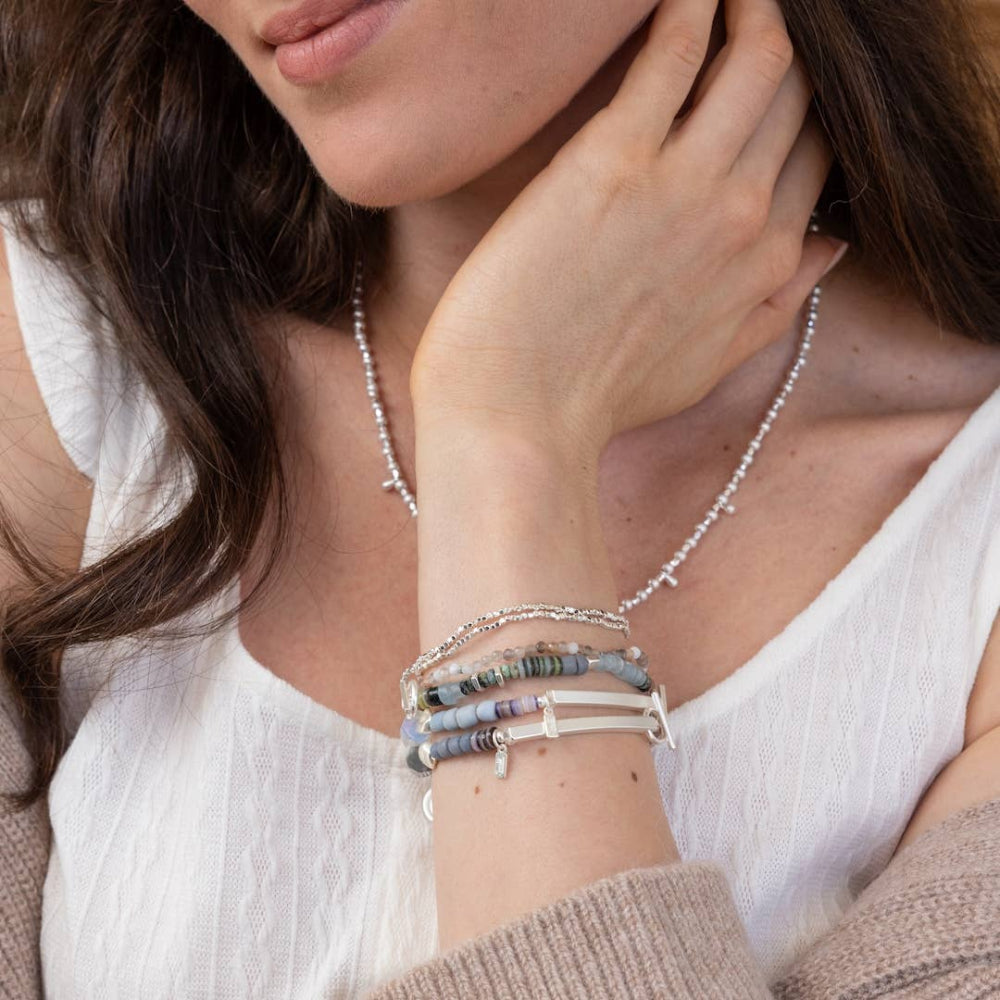 Woman wearing collection of Scout Hidden Message bracelets