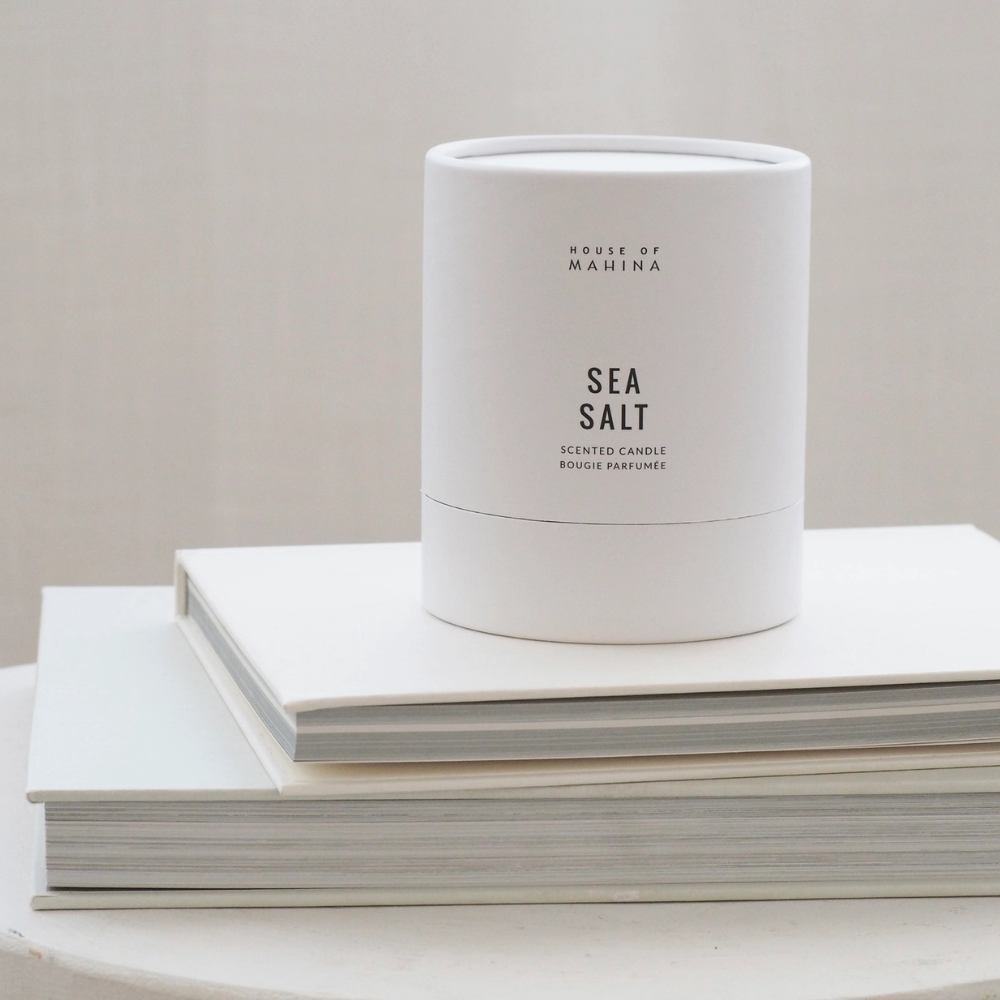 Sea Salt round candle box on stack of white books