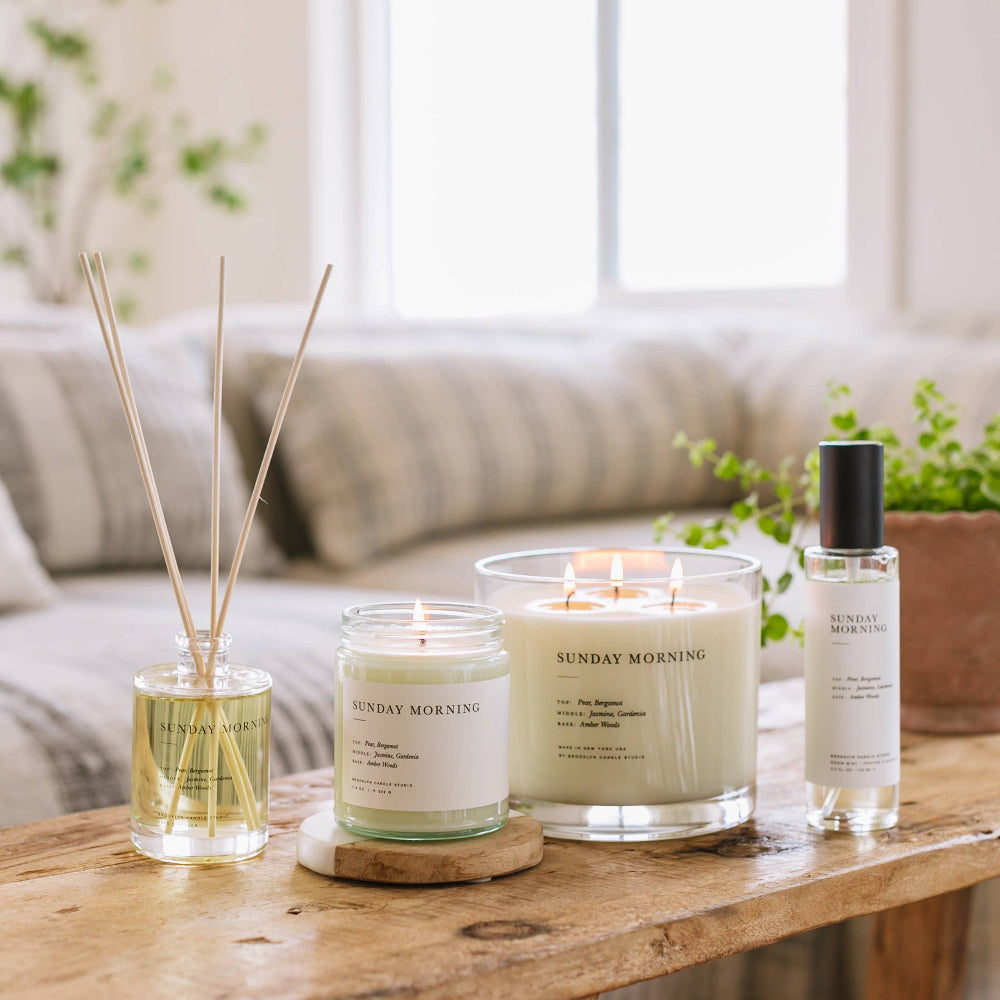 Brooklyn Candle Studio candles and diffusers on a wooden table in a cozy room