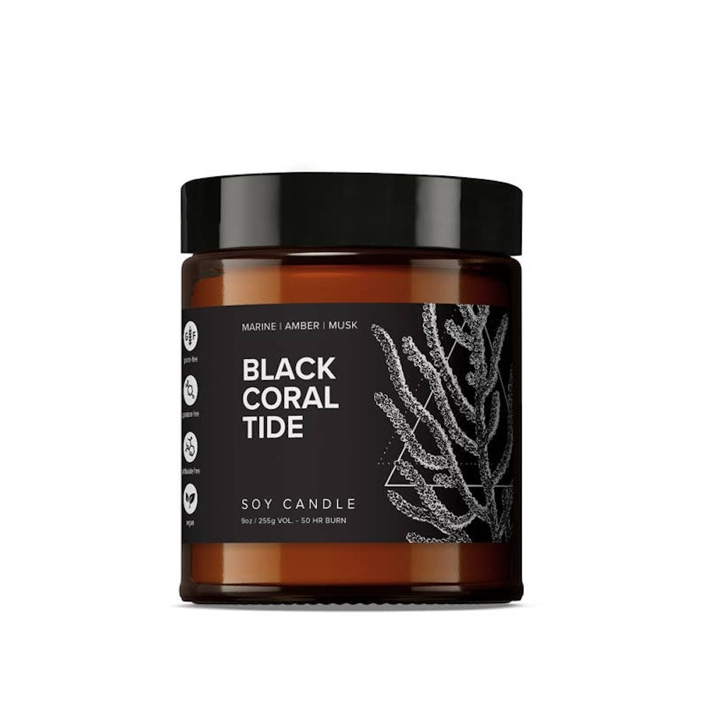 A black jar of Black Coral Tide soy candle with a design of coral reefs on the label.