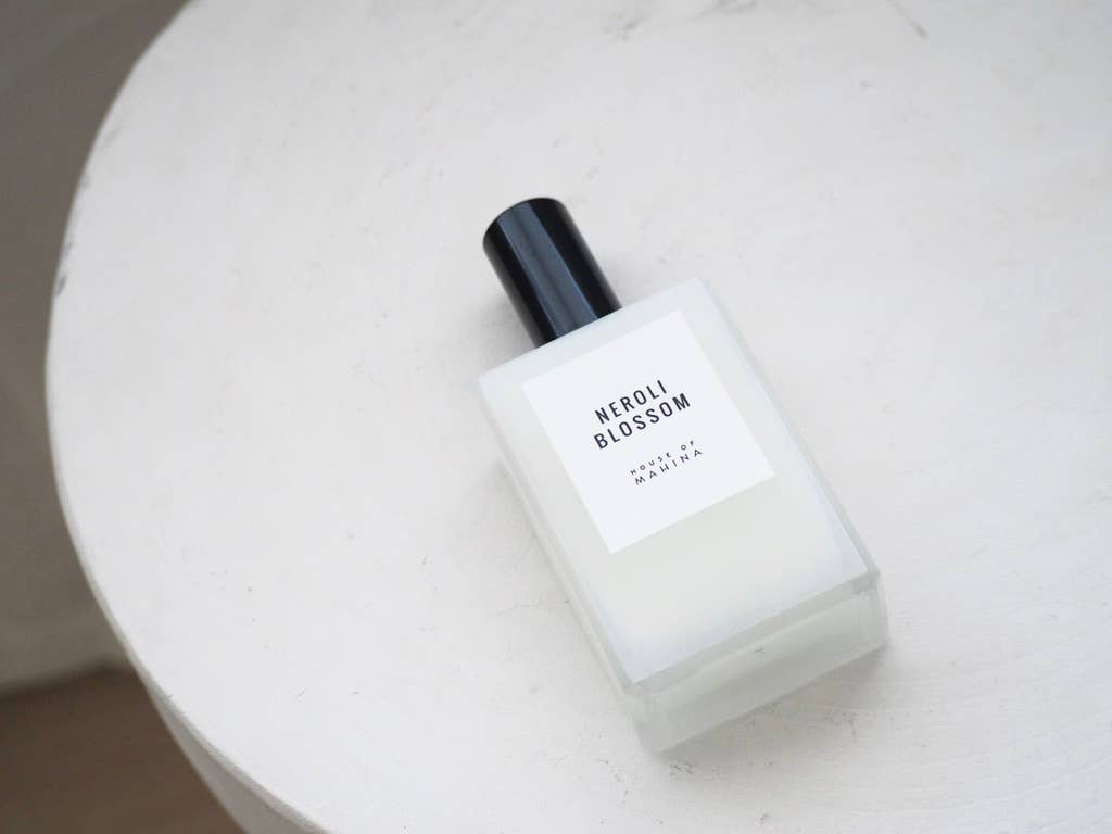 Neroli Blossom mist bottle lying on its side on a white textured table